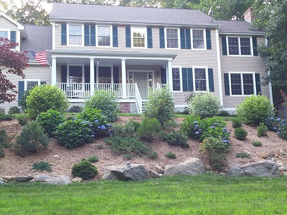 Perched above the road like a beacon, the inviting front porch beckons you to sit awhile and admire the flowers, gaze out at the river to catch sight of a heron, or sit and listen to the rain fall. This is home.