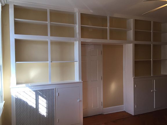 Living room offers ample shelves and cabinet space.