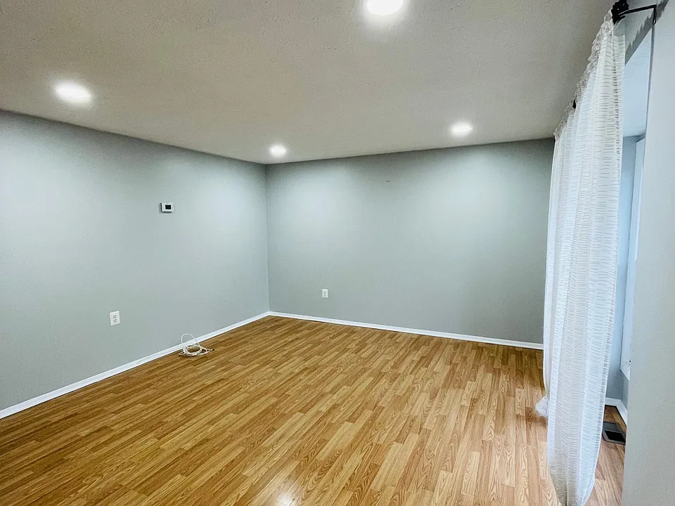 Living room with 2 large windows for natural lighting and modern recessed lighting.