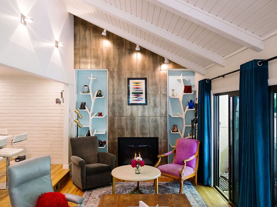 Vaulted ceilings and open floor plan on the main level and sliding doors open to the fenced in landscaped backyard
Furniture and art are not included.
Custom tree bookshelves and all window coverings are included.