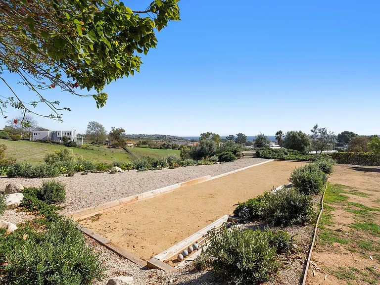 A regulation-sized bocce court with panoramic hillside views.