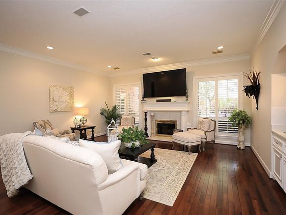 The family room with hardwood flooring, plantation shutters, crown molding and flanked by the exquisite gas log fireplace really gives this room the "wow" factor.