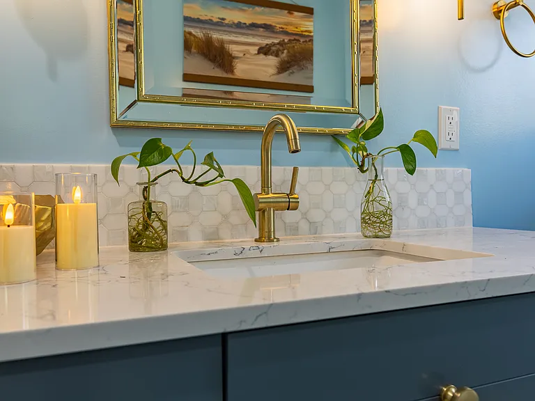 Glacier Bay water faucet with wide vanity sink space. Long mirror above the sink to add heighten dimension to the room.