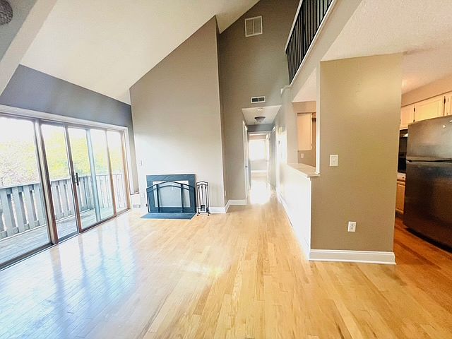 Living area with high ceiling,skylights and patio doors to balcony