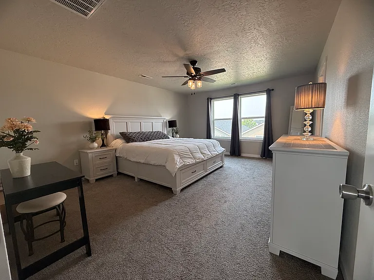 Spacious primary bedroom with large windows and plenty of natural light. Room size about 13'8"x 17'8".