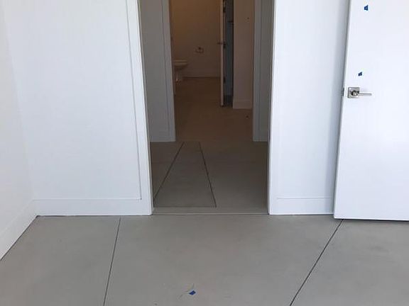 Entryway to closet and bathroom through bedroom