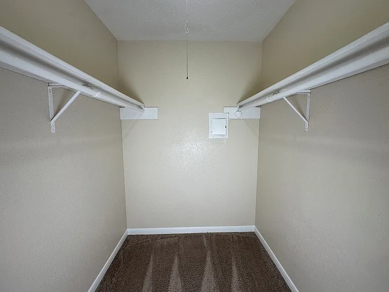 Spacious walk-in closet with ample shelving, ideal for organized storage and maximizing space. Spacious walk-in closet with ample shelving, ideal for organized storage and maximizing space.