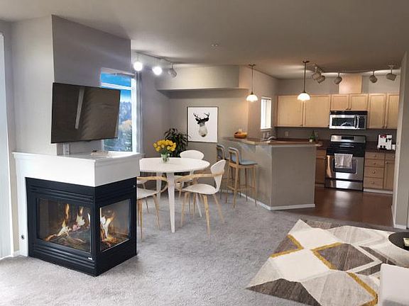 Enjoy the views while dining next to the fireplace. Stare at the view out of your kitchen window while cooking on your gas range, Cabinets and counter top abound.