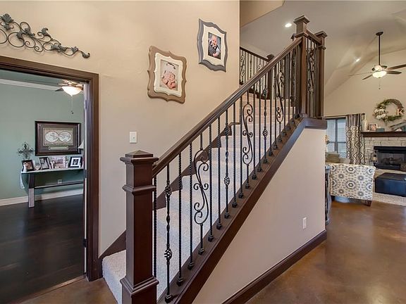 Soaring entry!  Stair with iron spindles and view into spacious office and comfortable living.