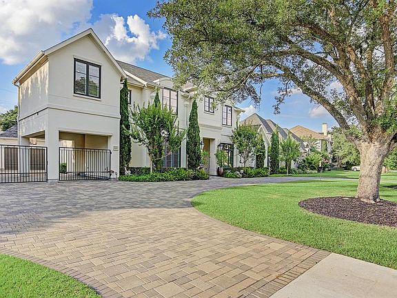 Pavers provide a lovely touch to the circular driveway. Double wide entry to motor court, porte cochere and three car garage.