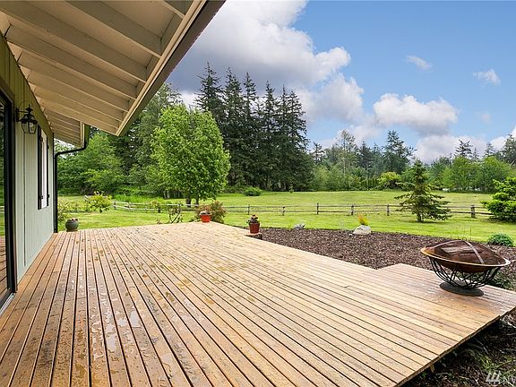 Generously sized back deck located off family room and kitchen overlooks the pasture. Lots of great sun, perfect for barbecues and sunsets around the fire. (Firepit is included!)