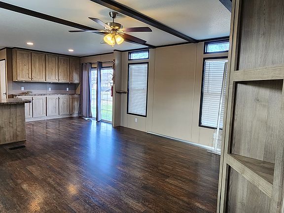 Front door view of den/kitchen peninsula/dining area with buffet and sliding glass door access to the back deck.