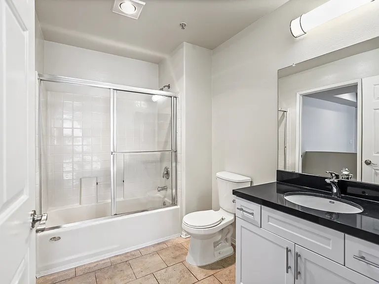 Large-Size Bathroom with Bathtub with a Glass Door and Cabinet Storage