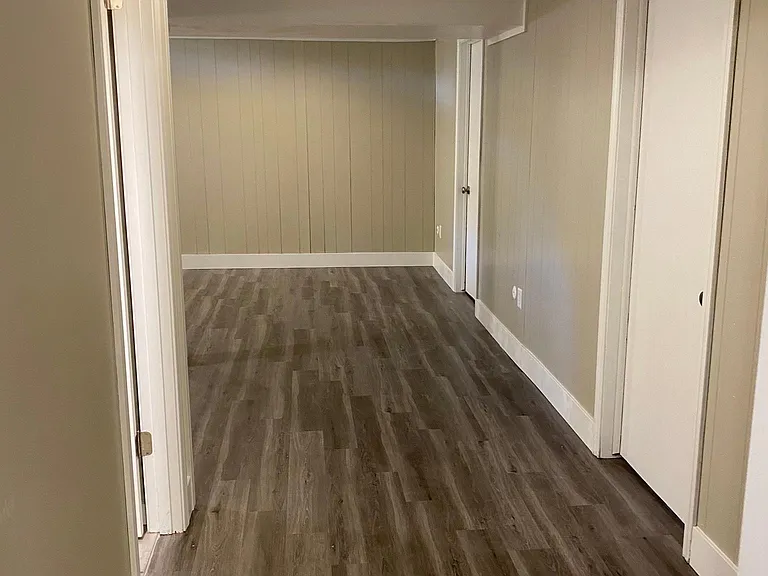 Basement living area heading to bedroom.