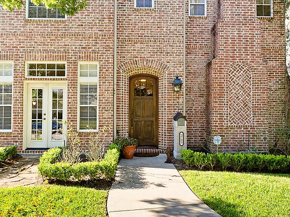 8' Custom mahogany front door highlighted with a natural gas lantern. French doors lead from the din