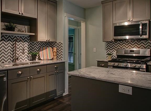 Designer kitchen with gorgeous tile and beveled granite countertops! Featuring all new stainless steel appliances, including a 5-burner gas cooktop.