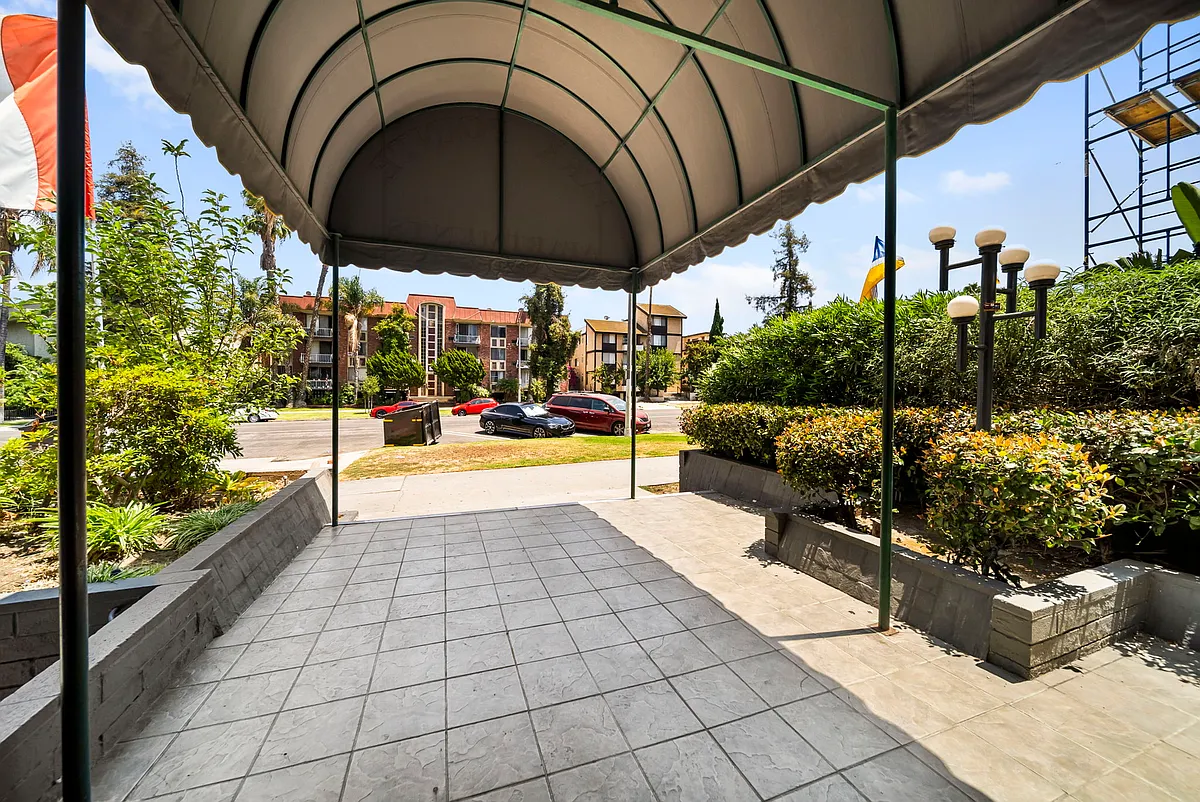 Inviting covered entrance featuring landscaped grounds and convenient access to the community. - Park Pointe