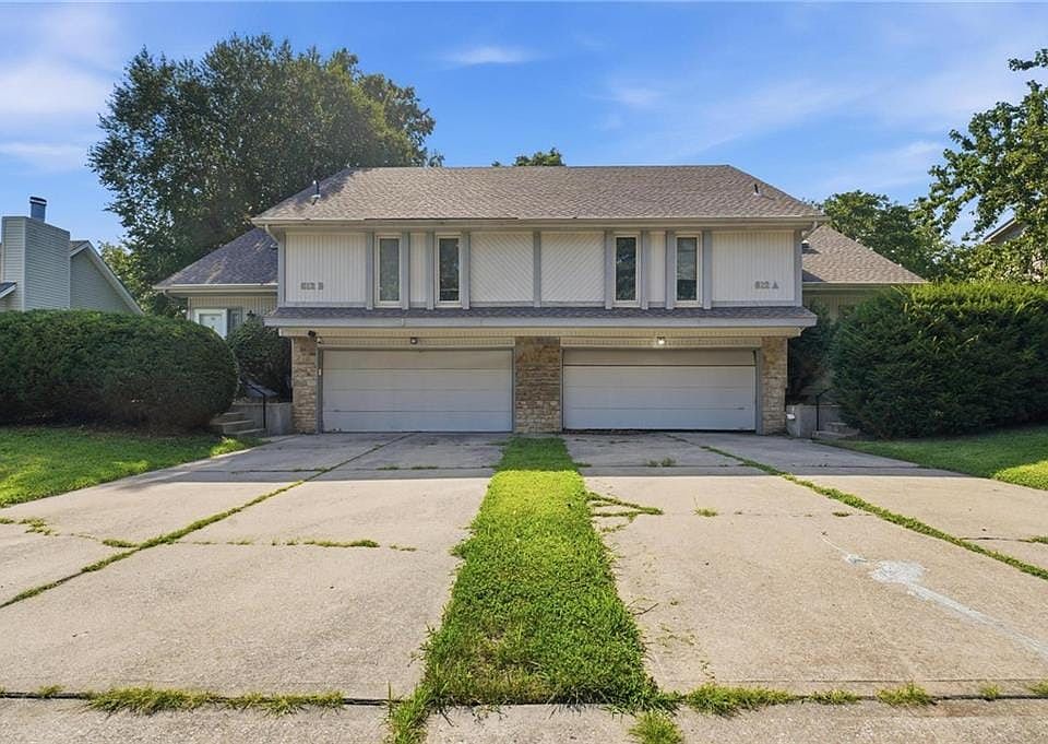 Duplex-style property featuring two distinct units, each with an individual garage and separate entrance