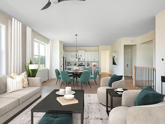 Modern open-plan living space with a beige sofa, round coffee table, and teal dining chairs set agai
