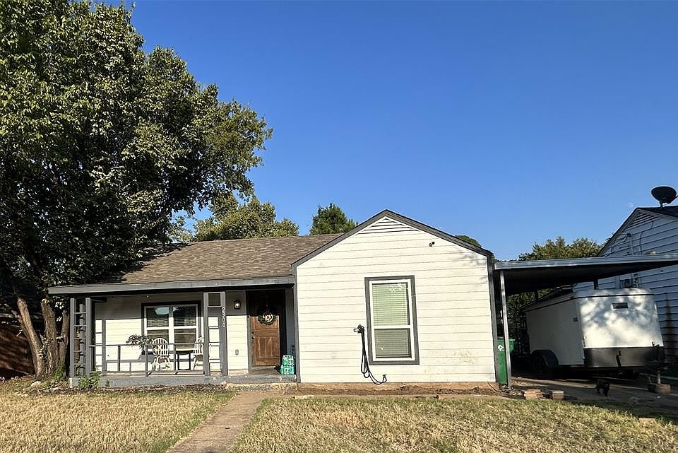 Bungalow-style home featuring covered porch, a front yard, a carport, and roof with shingles
