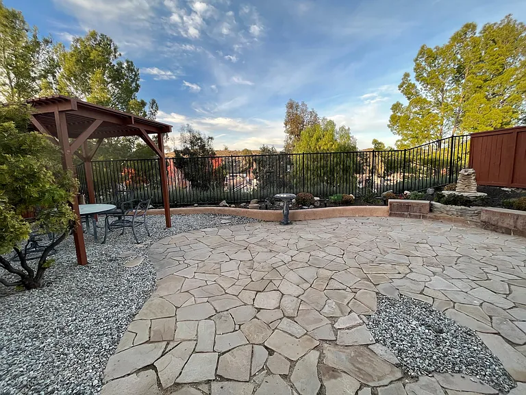 Large, fully landscaped rear yard with pergola, gas BBQ, and stunning views.