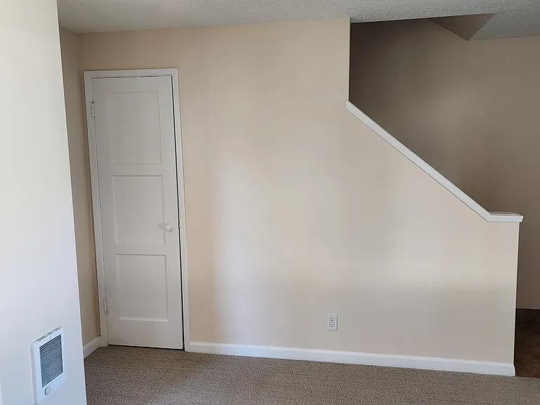 Front Room with coat closet and stairway to second floor.