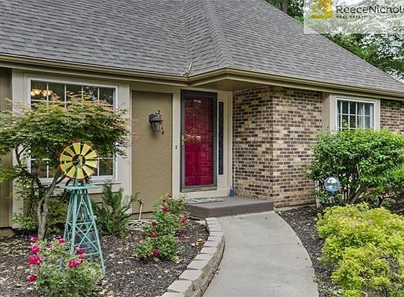 Beautiful landscaping greets guests as they enter the home.