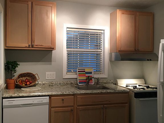 The kitchen with with all new cabinets, dishwasher, stove, track light, and to the right edge of the picture, a glimpse of the new refrigerator.
