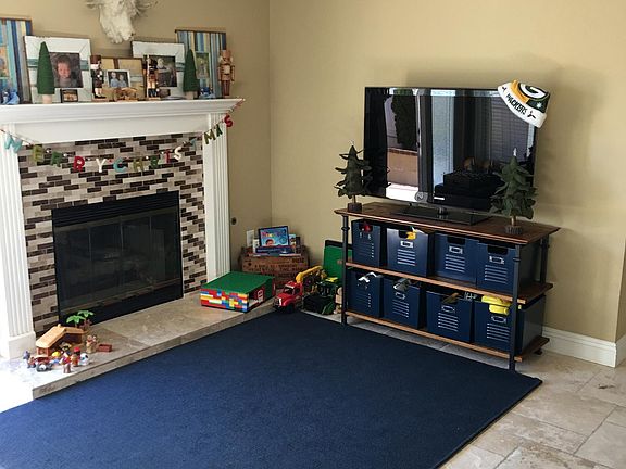 Family room has a gas fireplace, overhead lighting and ceiling fan. Lots of gorgeous light and beautiful stone floors.