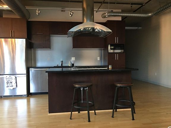 View of kitchen and kitchen island from living room