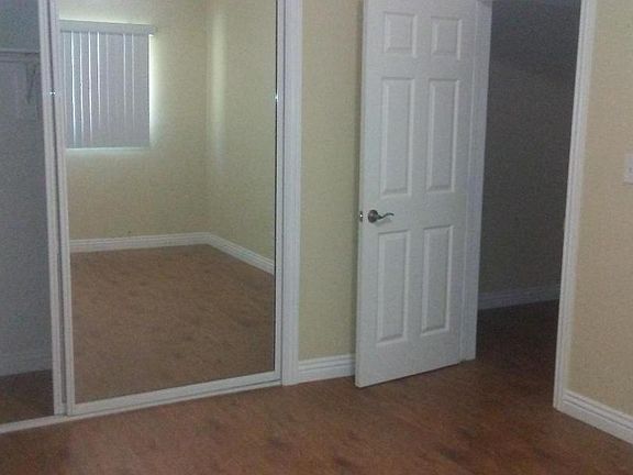 bedroom with large closet and mirrored doors; hardwood floor