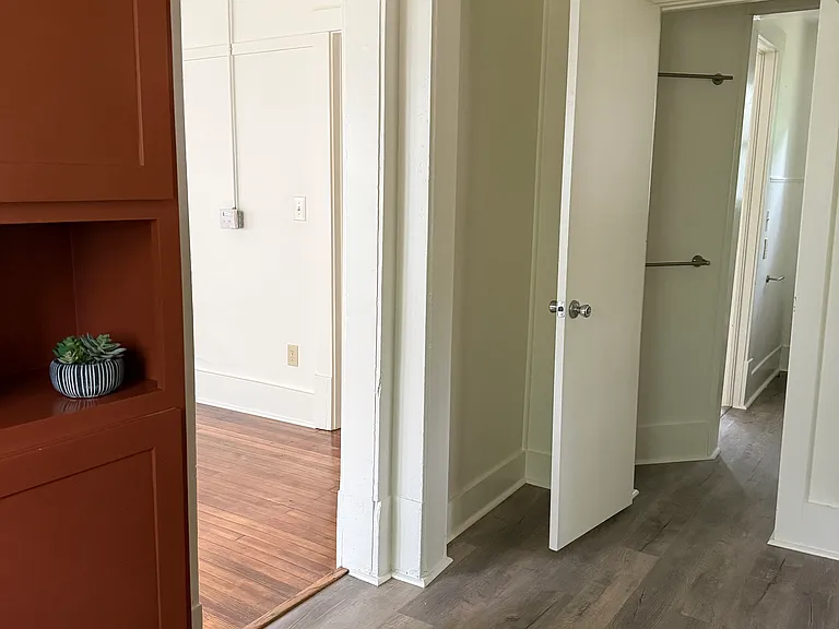 Kitchen pantry cabinet (left) has a space for a microwave. Looking toward the bathroom entry.