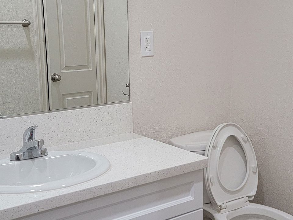 Bathroom with white vanity and toilet at Orlando Woods Apartments in El Cajon, California.