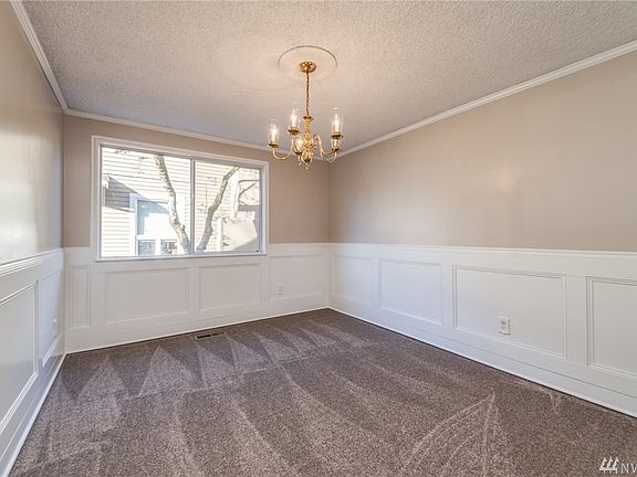 Formal dining room with paneled wainscoting and crown molding