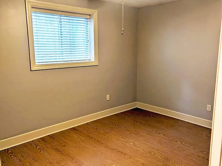 Bedroom with hardwood floors at Auburn Apartments.