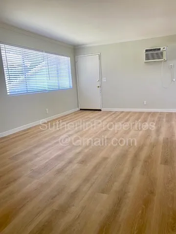 East facing view of living area with wall AC and lovely large window