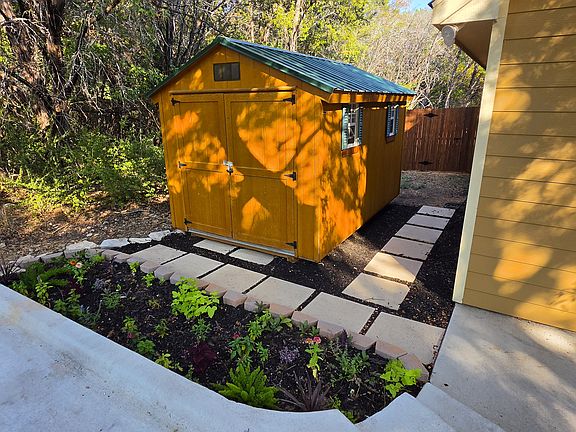 Lockable storage shed. Flower bed. Stone walkway