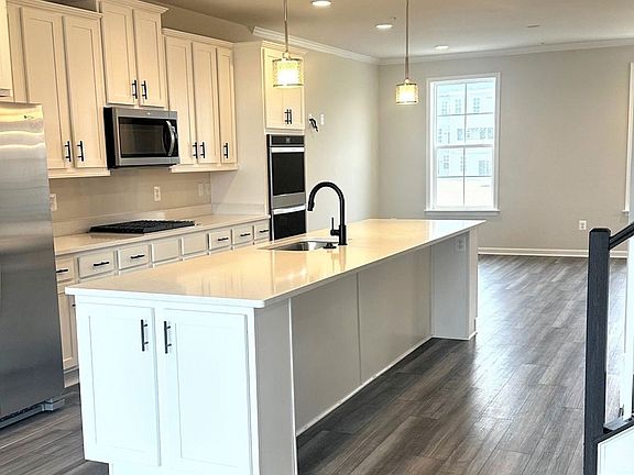 Island kitchen and front living room in a DRB Homes Harlow II plan at the Laurel Overlook community.