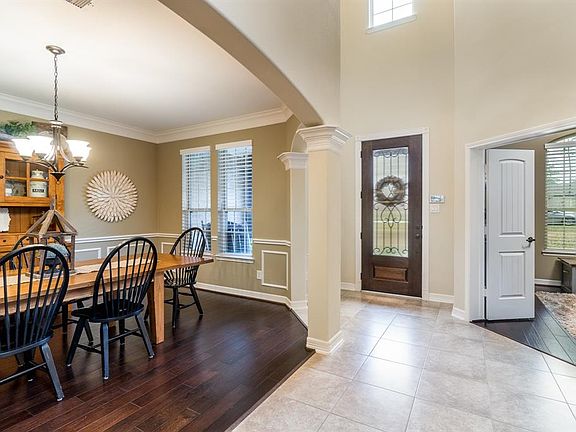 Foyer with high ceiling is open to the dining with the study nearby.