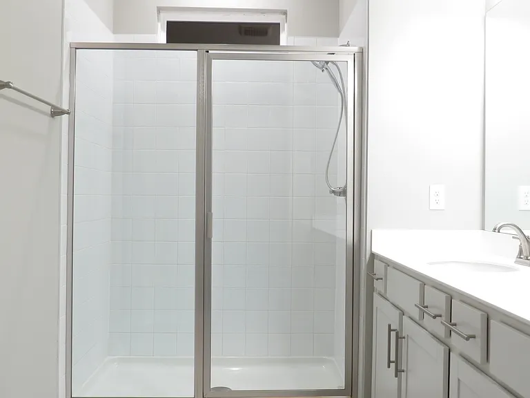 Large shower with glass doors and elegant bathroom accessories