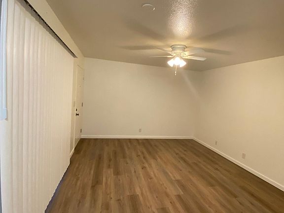 View to front door from kitchen. To the left are sliding blinds leading out to patio.