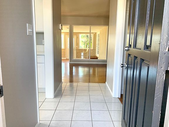 View of entryway into the home. Kitchen is to the left and living room is straight ahead, with the sunroom in the background.
