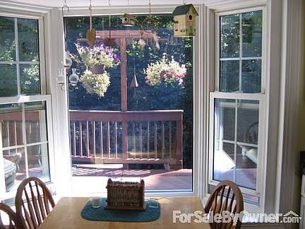 Deck view through bay window in kitchen
						:
						Cedar plant hanger is part of the deck railing