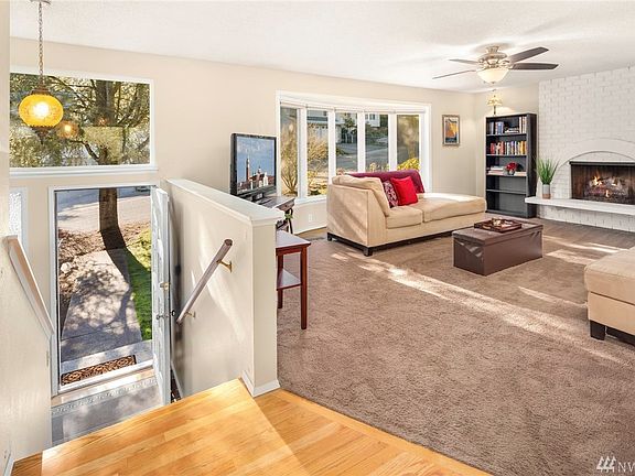 Upper level living room centered around the trendy white painted brick wood burning fireplace, soaked in natural light!
