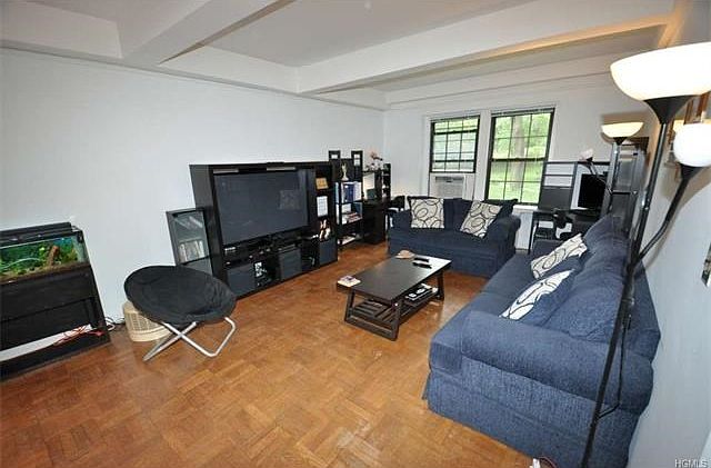 The living room looks out at the manicured courtyard and has an arched opening to the dining room. T