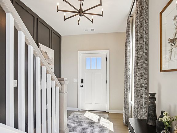 Entry with accent wall, front door, and staircase