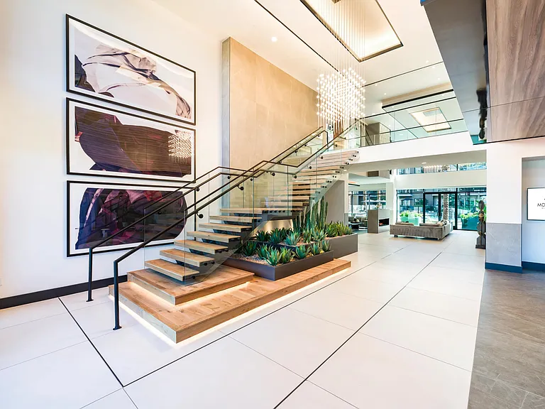 A sculptural staircase, statement lighting, and soaring ceilings create a striking entry that sets the tone from the moment you arrive.