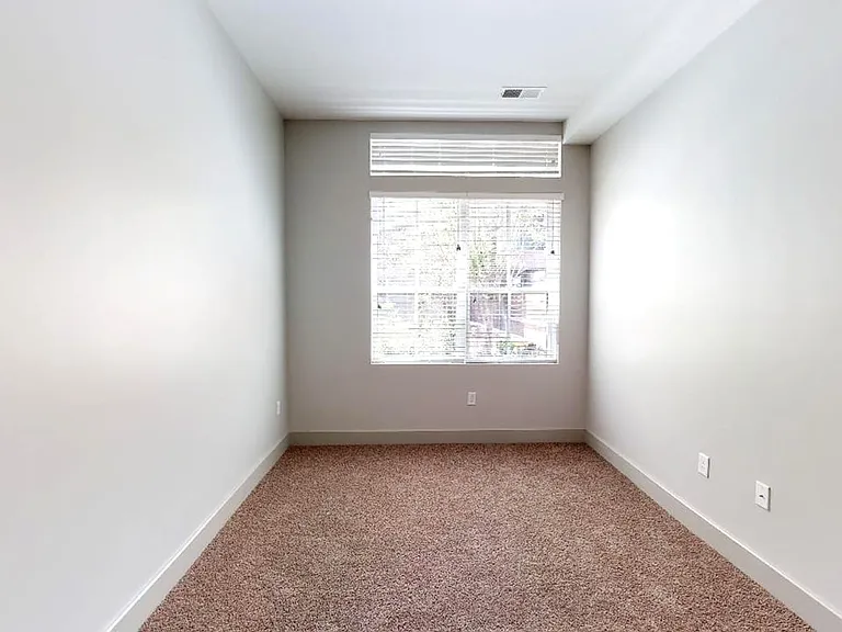 Spacious apartment bedroom with plush carpet flooring