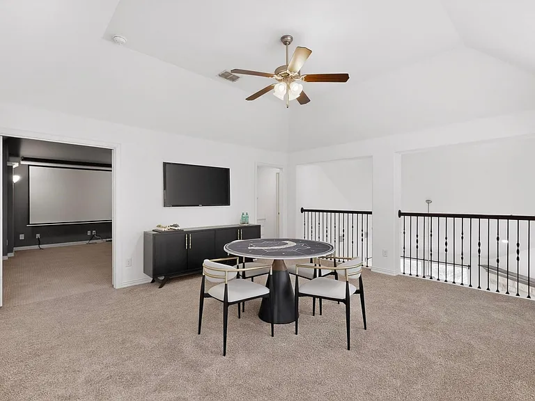A spacious den with a ceiling fan, creating a comfortable space.