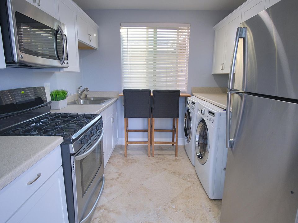 Kitchen with stainless steel appliances: stove, microwave, refrigerator. Full size washer and dryer